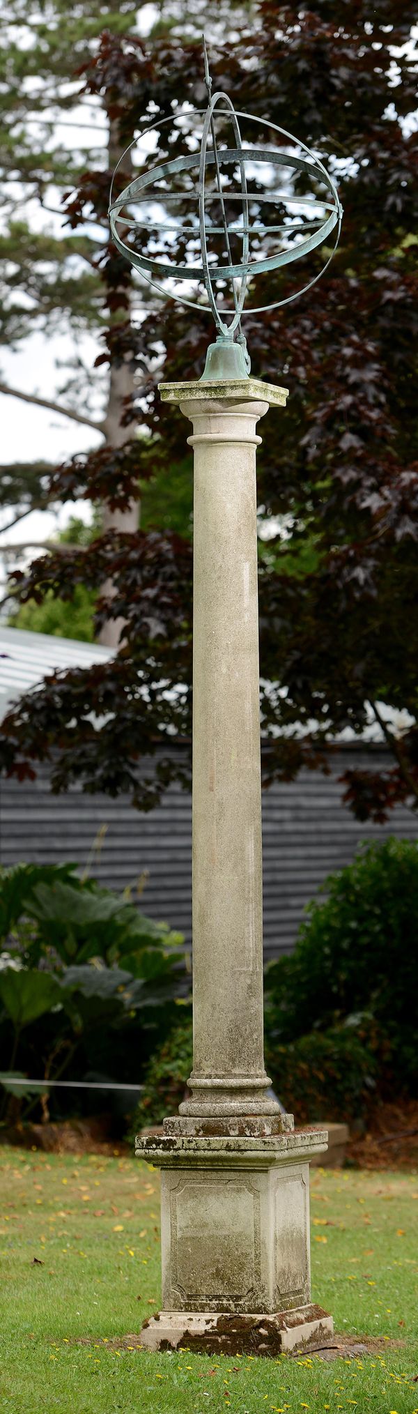 A carved limestone column with copper armillary sphere  modern  376cm high