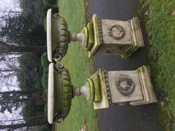 A pair of composition stone urns on pedestals late 20th century 123cm high, together with another smaller pair of composition stone urns on...