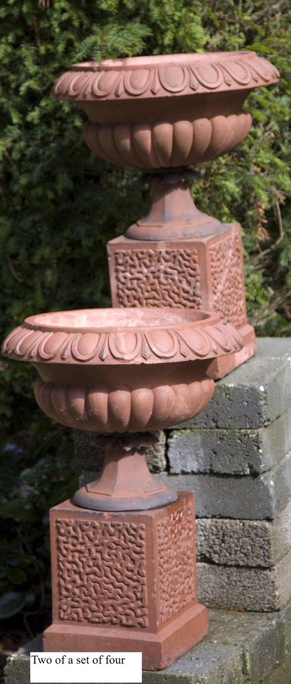 A set of four late Victorian terracotta urns on pedestals circa 1900 66cm high  