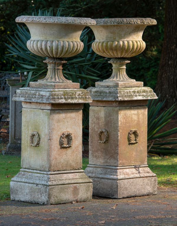 A pair of composition stone urns on pedestals  late 20th century  148cm high
