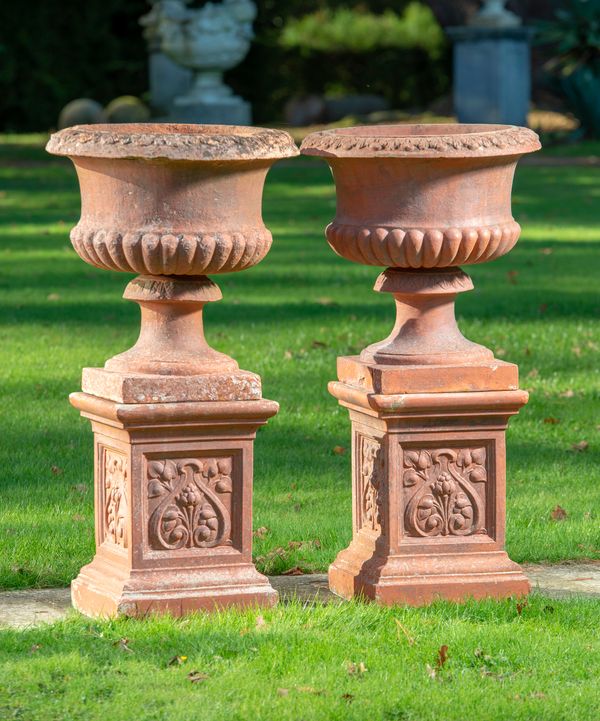 A pair of terracotta urns on pedestals early 20th century 90cm high