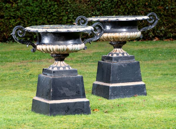 A pair of cast iron urns on pedestals 2nd half 20th century  76cm high by 90cm wide 