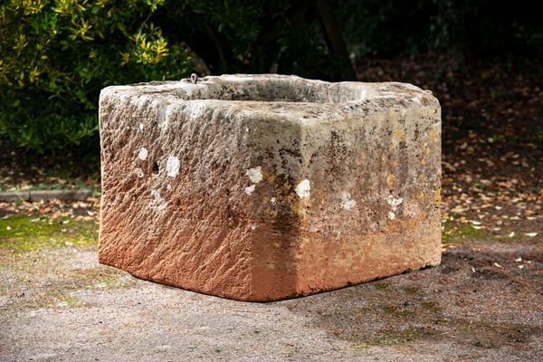 A carved limestone wellhead 66cm high by 100cm square