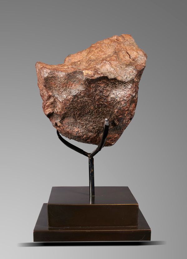 A meteorite   Tindouf, Algeria class H5, on bronze base 26cm high overall 