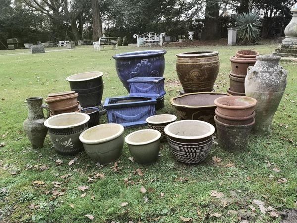 A collection of glazed earthenware planters and flower pots together with two Greek-style amphorae  and three stands  the largest 60cm high From the...