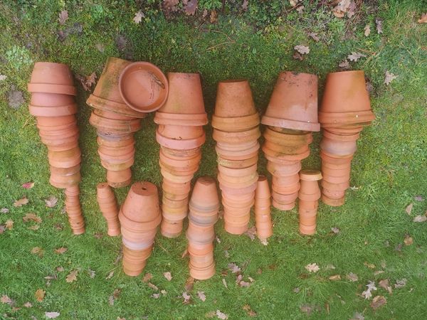 Approximately 100 terracotta flower pots late 19th century onwards including some hand-thrown examples and some with maker‘s stamp the largest 16cm...
