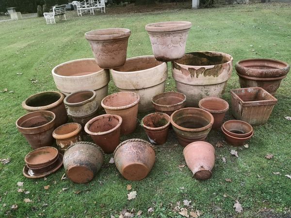 A large collection of terracotta flower pots, jardineres and trays 19th century and later the largest 50cm high, together with three terracotta wall...
