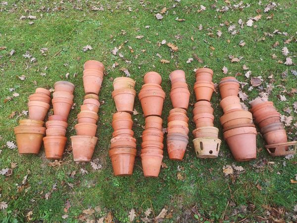 Approximately 100 terracotta flower pots late 19th century onwards including some hand-thrown examples and some with maker‘s stamps, together with...