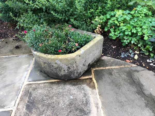 A carved stone trough 27cm high by 53cm wide by 61cm deep (plants not included) From the personal collection of Tim Wonnacott.  See lot 400 for...