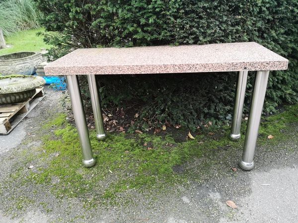A stainless steel table modern with rectangular pink Balmoral granite top 137cm long by 58cm wide From the personal collection of Tim Wonnacott. ...