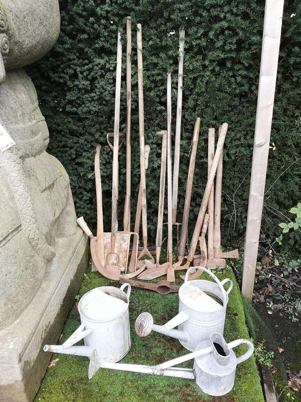 A collection of vintage garden tools including mattock, hayfork, wheeled edging shears, hoes, edging spades, slashers, billhooks, axe handle, sledge...