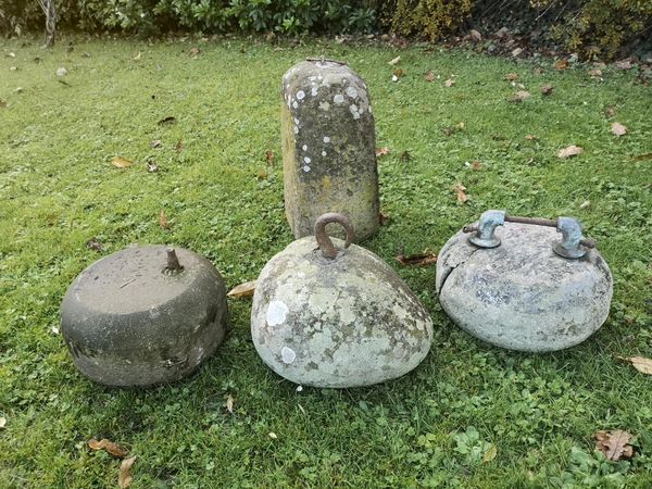 A stone cheese weight with iron hook another cheese weight 38cm high, and two curling stones the cheese weight 28cm wide From the personal...
