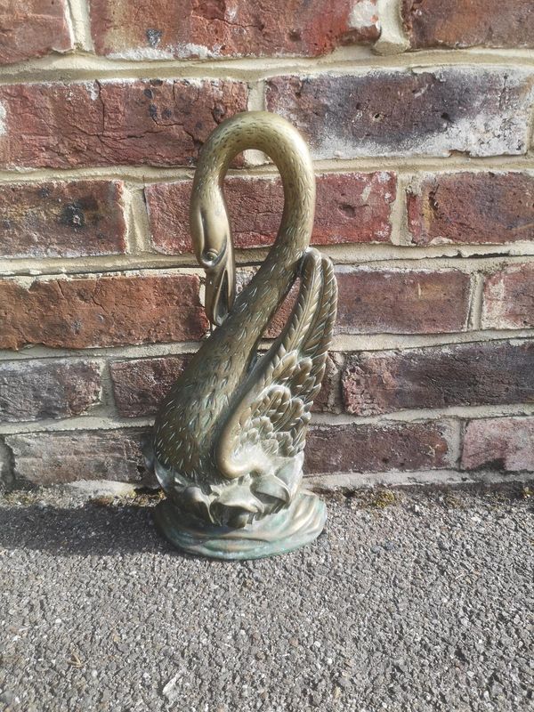 A Victorian brass doorstop in the form of a swan late 19th century 39cm, together with a cast iron boot scraper, 35cm high