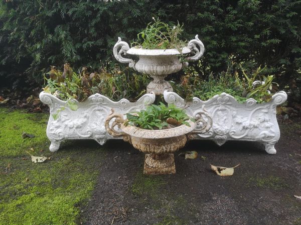 A pair of cast iron planters French, early 20th century 50cm wide, together with a pair of small cast iron urns, 43cm wide