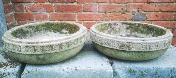 † A pair of carved sandstone shallow bowls
