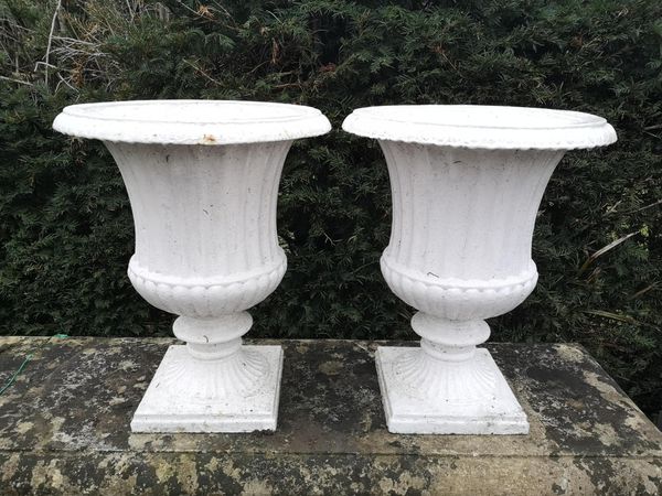 A pair of small cast iron campana urns 20th century 50cm high