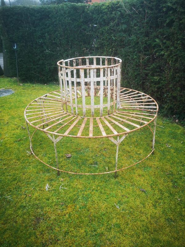 A wrought iron circular tree seat in two halves early 20th century 130cm diameter 