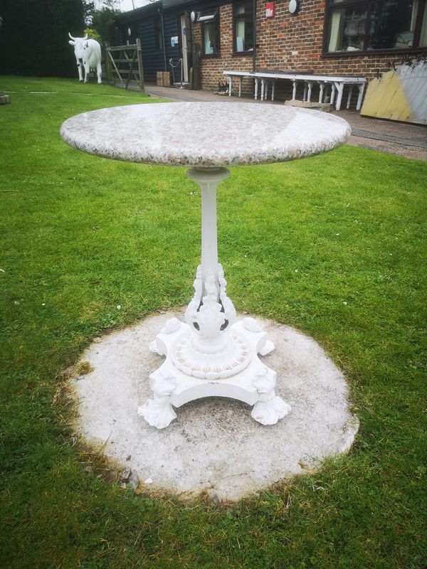 A cast iron circular table early 20th century with later granite top 61cm diameter