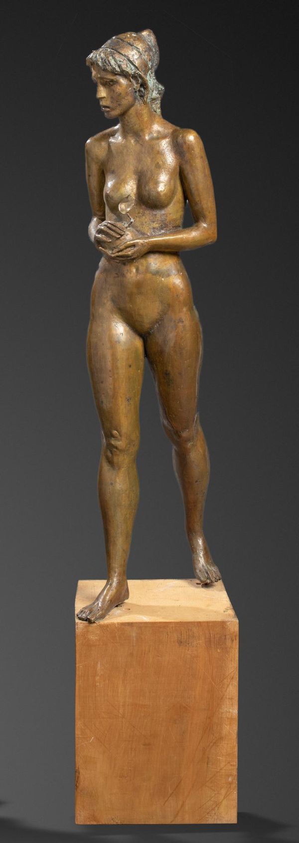 A bronze figure of a girl holding an apple 3rd quarter 20th century on stone pedestal figure 133cm high, 179cm high overall