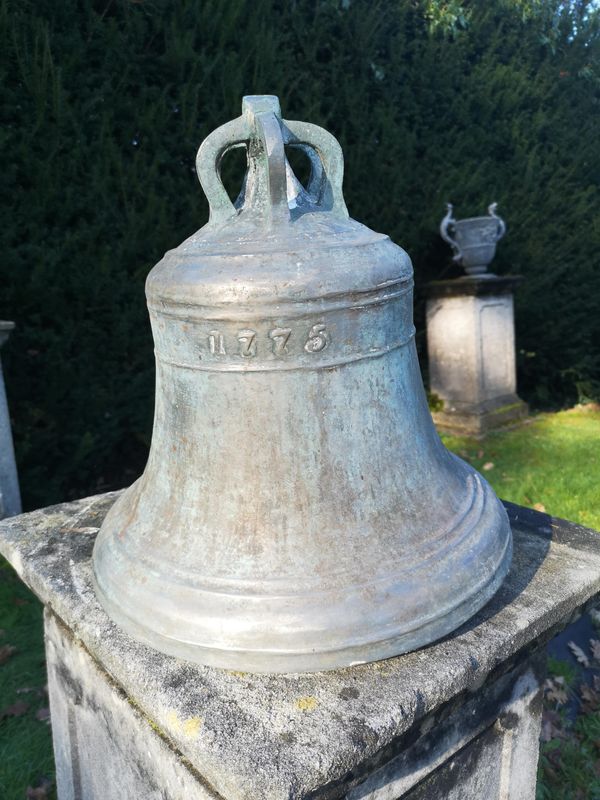 A Georgian bronze bell dated 1775 with clanger 40cm high