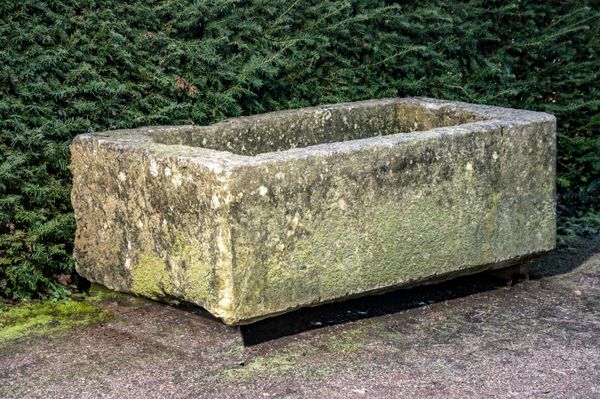 A carved stone trough 50cm high by 156cm long by 86cm deep