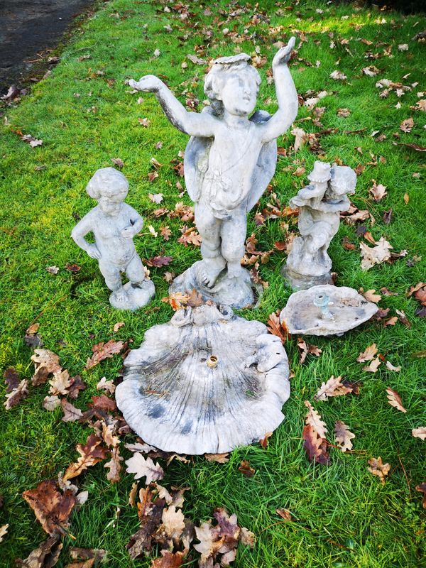 A lead bird bath in the form of a putto holding aloft a shell  early 20th century 70cm high, together with a smaller lead fountain, 43cm high and a...