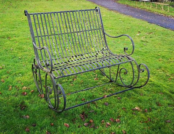 An unusual wrought iron conversation rocking chair 112cm wide