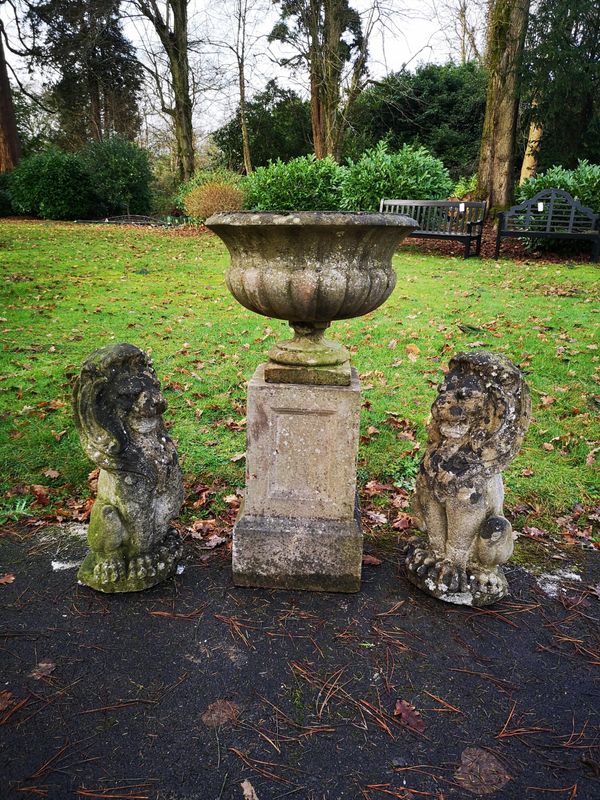 A pair of composition stone seated lions 2nd half 20th century 63cm high, together with a composition stone urn on pedestal, 2nd half 20th century,...