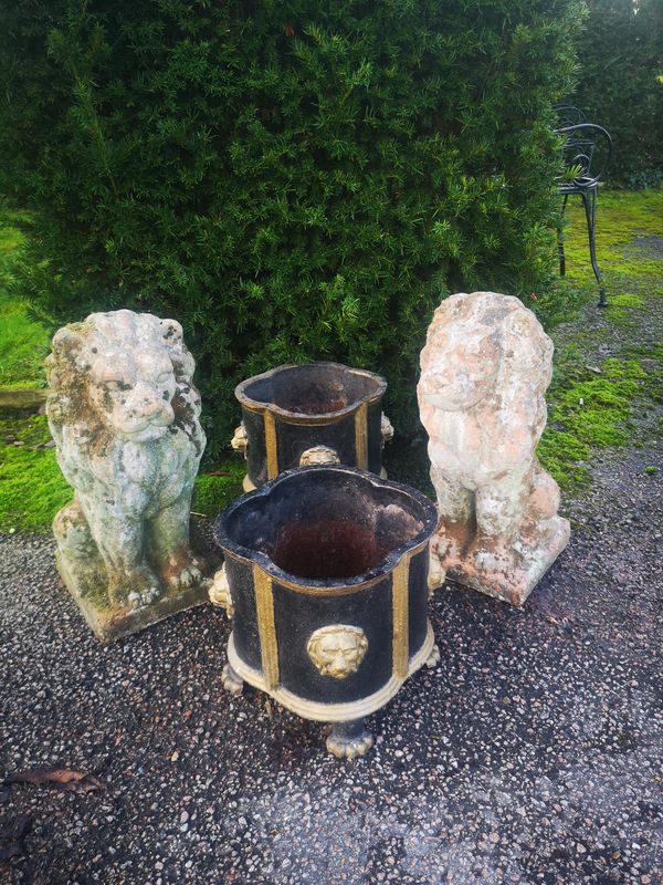 A pair of terracotta lions 2nd half 20th century 52cm high, together with a pair of lobed circular cast iron small planters, 20th century, 26cm high