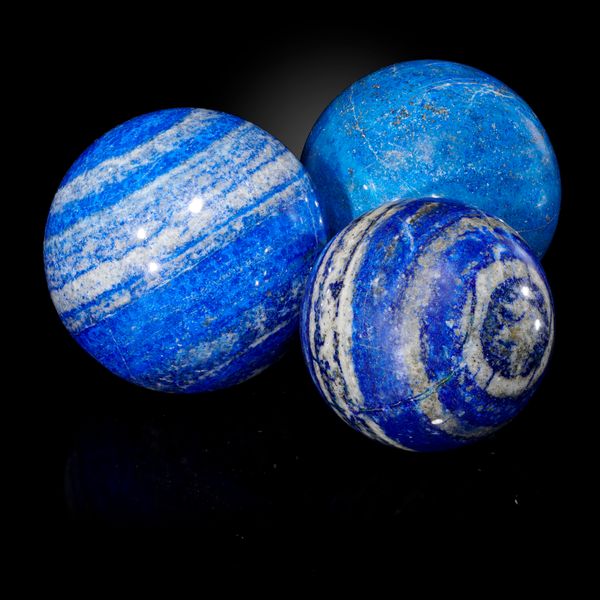 A set of three lapis lazuli spheres the largest 8.5cm diameter