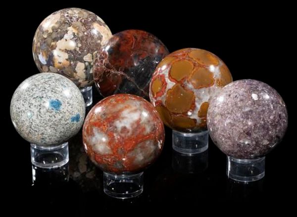 A collection of six mineral spheres  including K| Cobra jasper and fossil wood the largest 10cm diameter