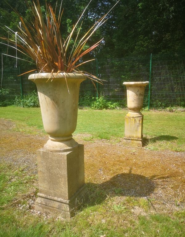 †A pair of carved sandstone urns on pedestals modern  120cm high 
