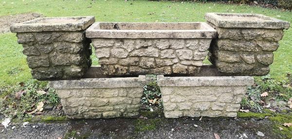 A collection of five composition stone planters 2nd half 20th century with rusticated decoration the largest 66cm wide