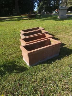 A set of four rectangular terracotta planters 60cm long, together with a further pair of rectangular terracotta planters