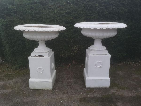 A pair of large cast iron urns on pedestals 2nd half 19th century 126cm high, together with a pair of cast iron plinths, 58cm high