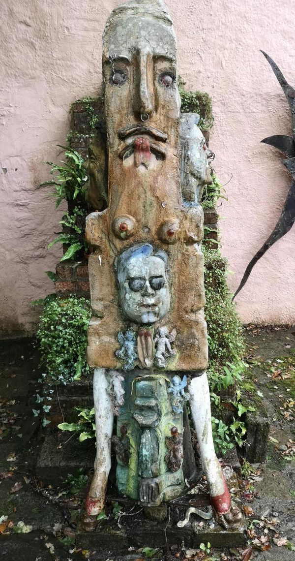 Gerald Moore Totem figure with applied cherubs Painted fibreglass 170cm high together with  Gerald Moore Agamemnon mask and helmet Ciment fondu and...