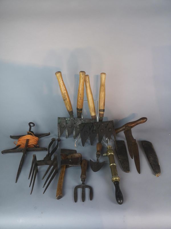 A collection of garden tools largely late 19th/early 20th century including peat cutter, hedge shears, markers and a gardener‘s axe, trowel etc.