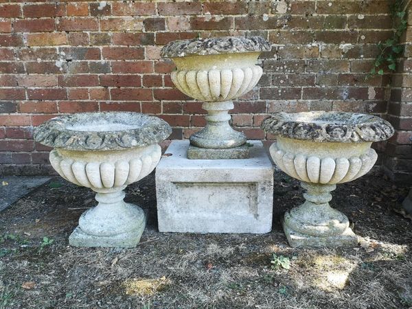 A set of three carved stone urns 48cm high