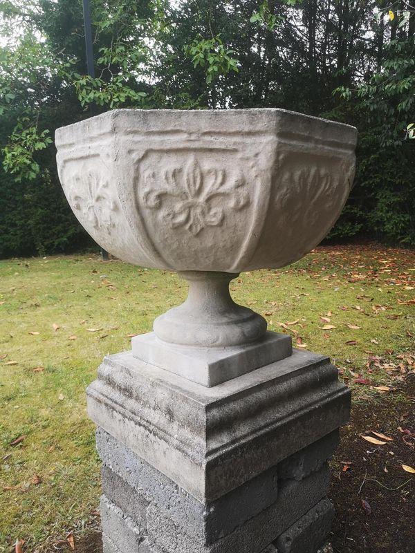 A composition stone urn modern 110cm high by 82cm diameter, together with another octagonal composition stone urn on plinth,  70cm high by 64cm wide