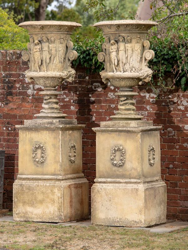 A pair of substantial composition stone urns on pedestals modern 292cm high This design is after an original cast iron urn made by the Coalbrookdale...