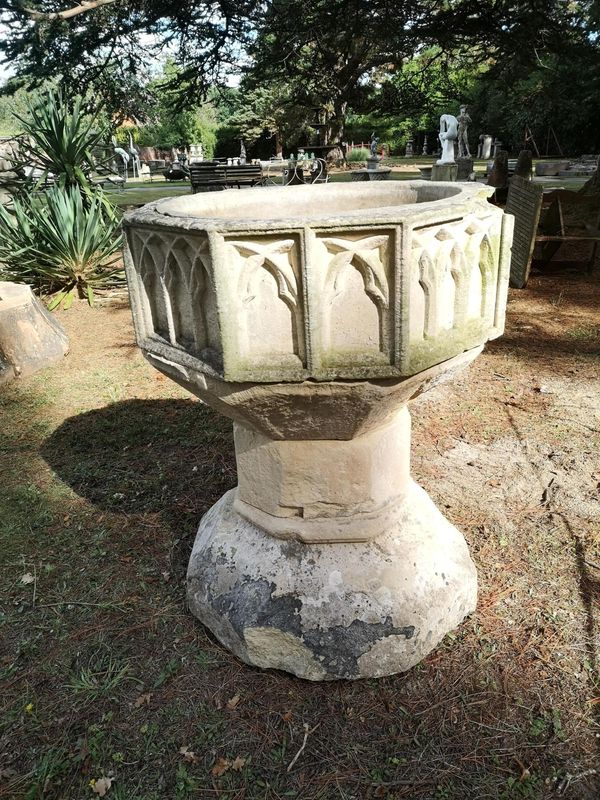 A Victorian Gothic carved stone font the centre section initialled HK and dated 1849 103cm high