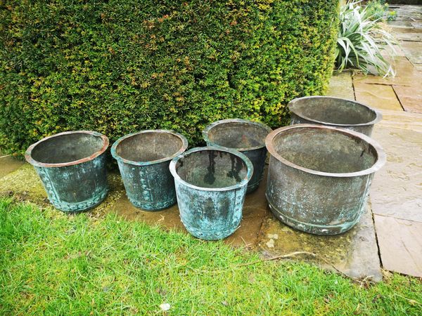 A pair of washing coppers 19th century  39cm diameter, together with a set of four later smaller copper type planters, 28cm