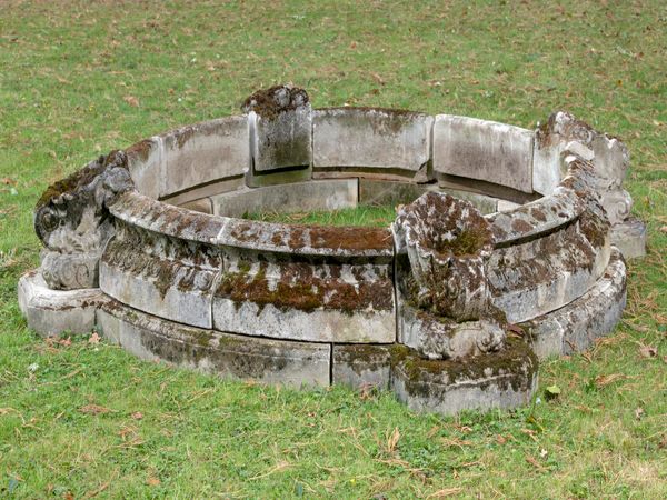 A composition stone circular pool surround late 20th century with scallop shell corners 50cm high by 270cm wide