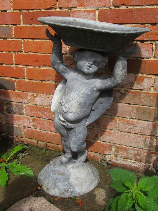 A lead birdbath in the form of a cherub supporting a basket 2nd half 20th century 74cm high