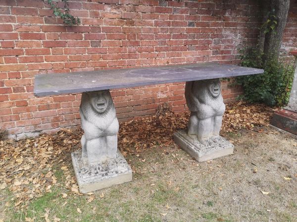 A slate table on grotesque animal composition stone supports 183cm long