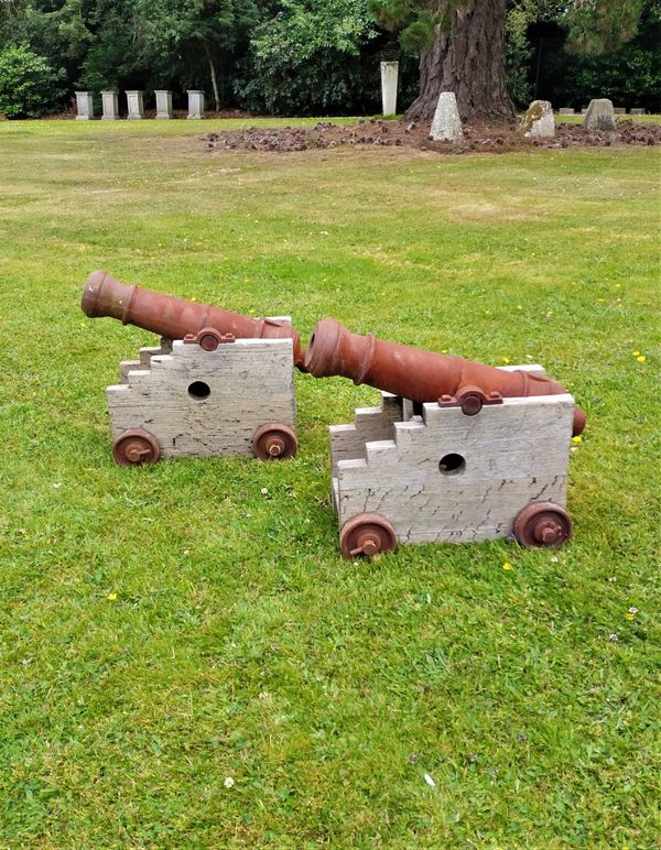 A pair of cast iron and oak signal cannons