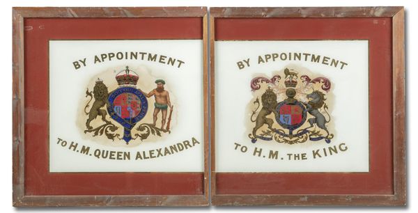 A pair of early 20th century painted and re-gilt glass Royal Warrant signs