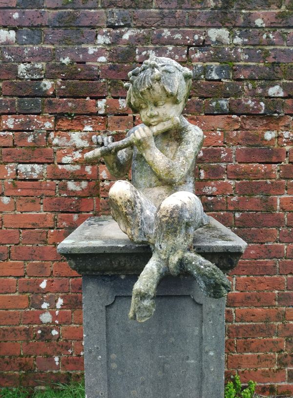 A similar composition stone faun playing the pipes