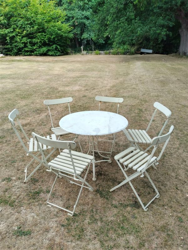 A suite of furniture comprising of 6 wrought iron and wood folding chairs and table with marble top