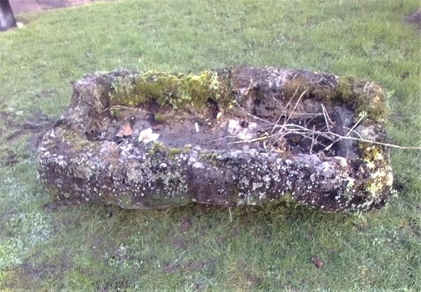A roughly hewn rectangular carved stone trough